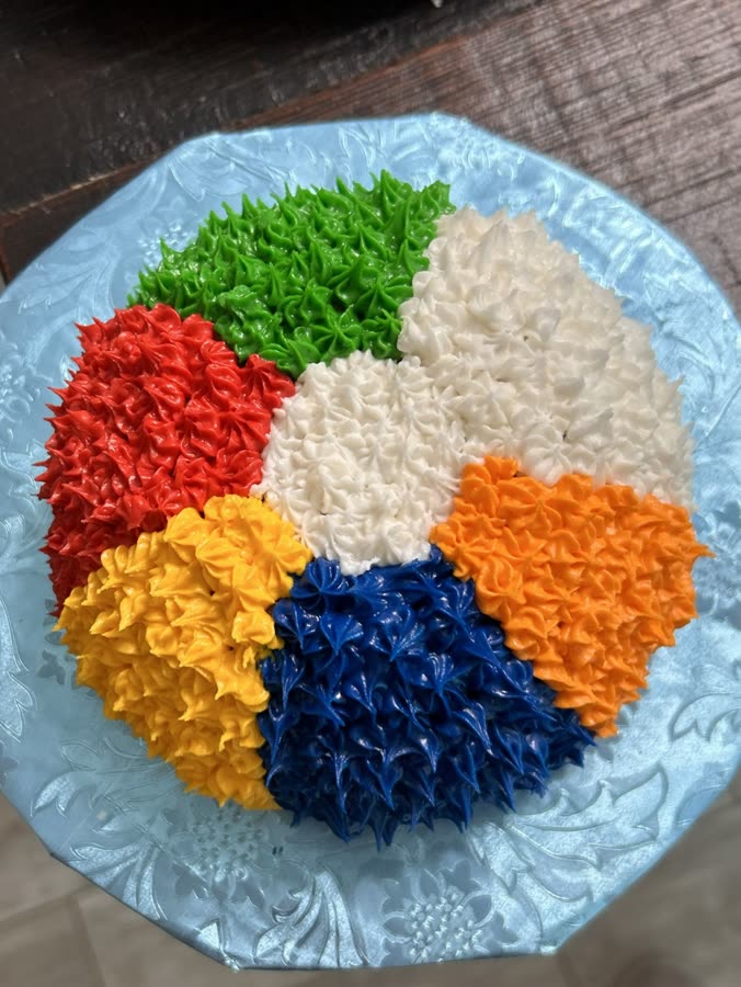 Beach ball cake piped in red, yellow, blue, orange, green, and white